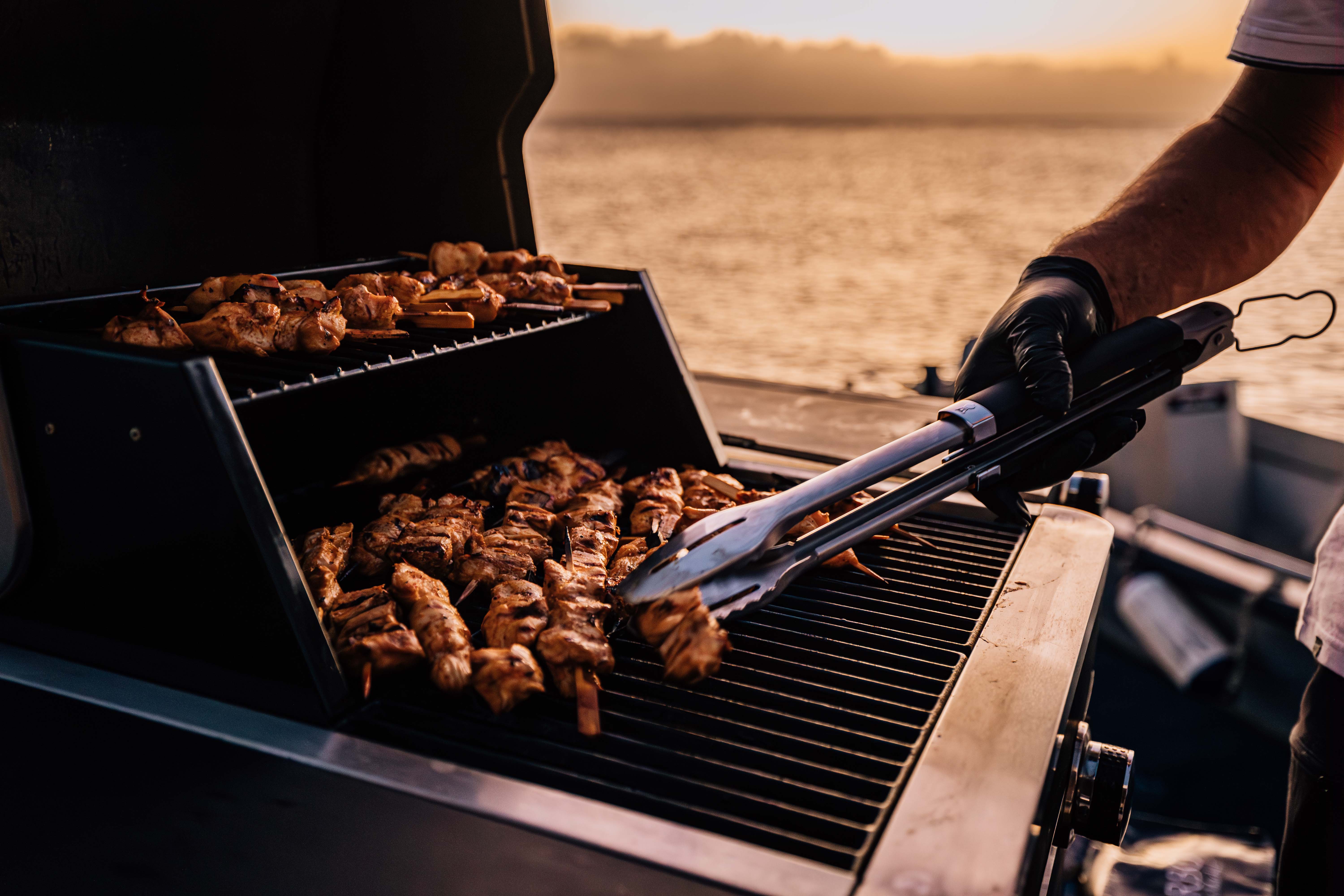 Skewers cooking on the on-board grill at sunset